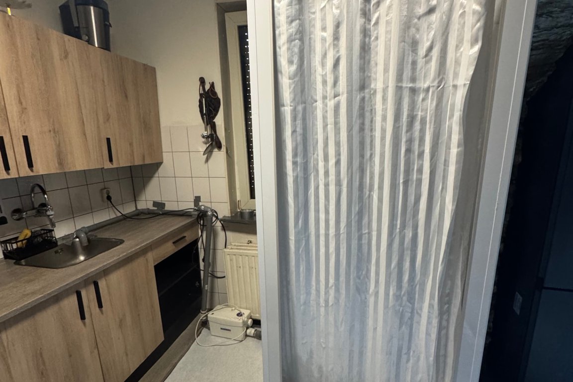 Tijdelijke mobiele douche in woning met vuilwaterpomp bij badkamerlekkage