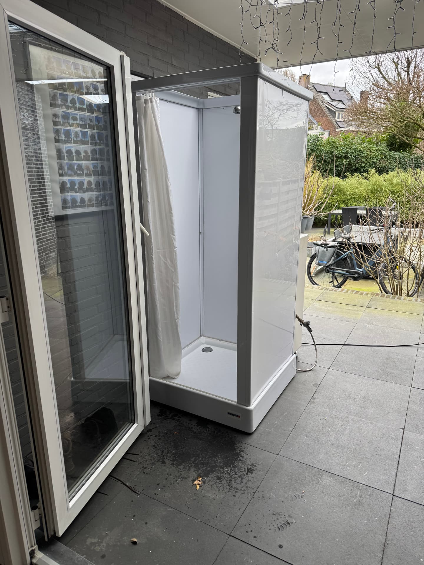 Mobiele douchecabine met open zijde op een terras