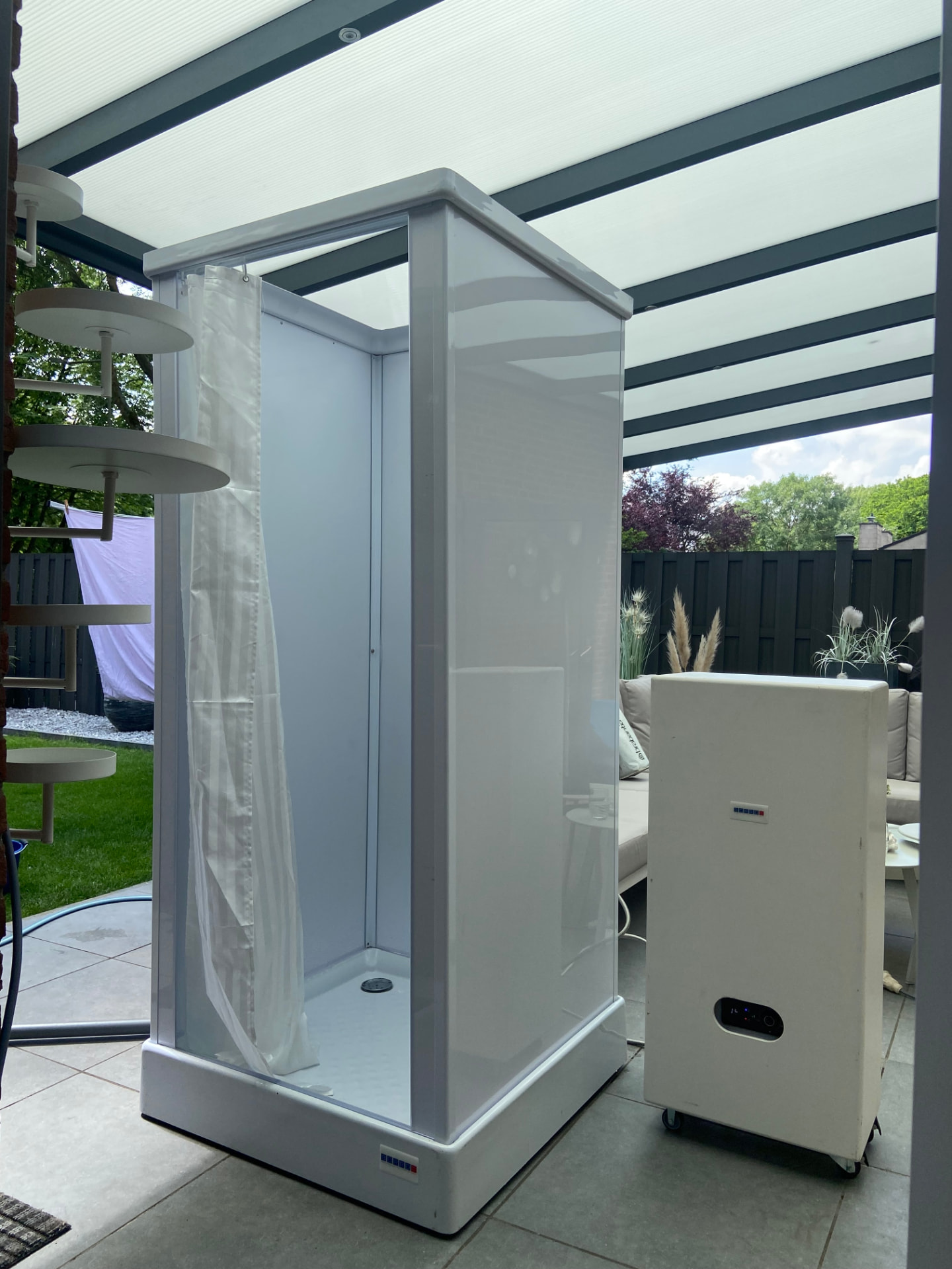 Mobiele douchecabine met mobiele boiler onder een overkapping in Brunssum