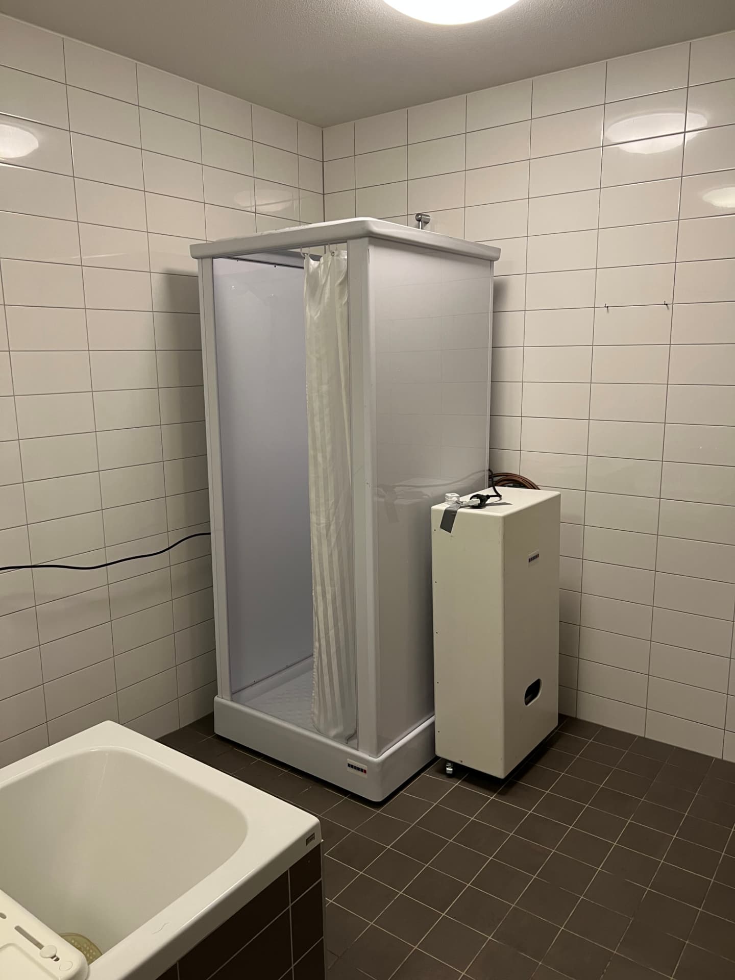 Mobiele douche met mobiele boiler in de bestaande badruimte van een bejaardenhuis in Susteren