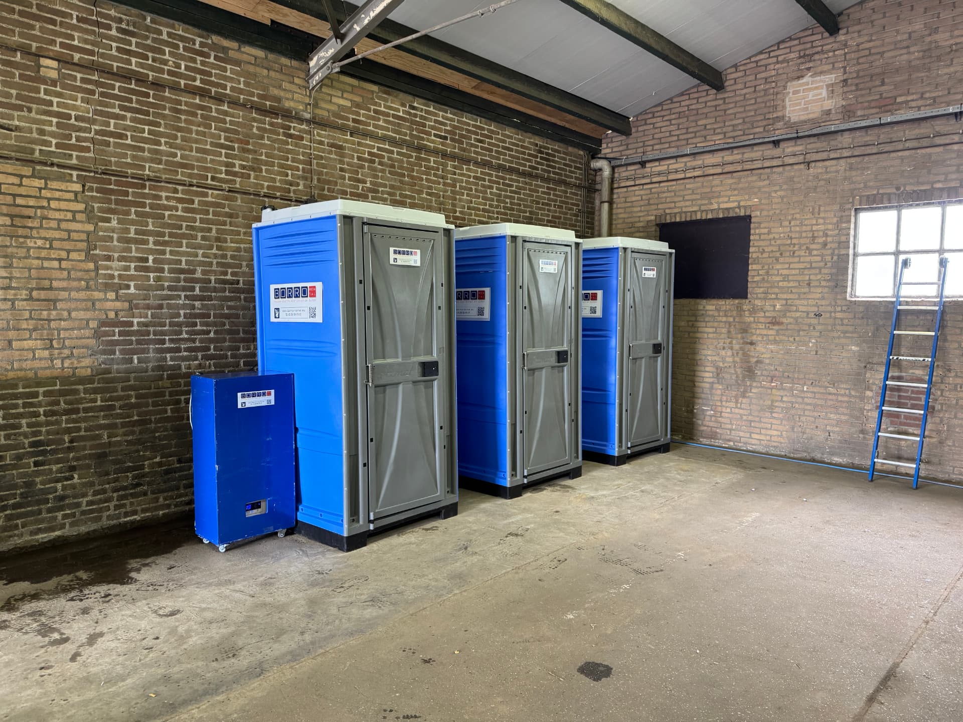 Mobiele buitendouchecabines met mobiele warmwatervoorziening in een bedrijfshal in Schinnen