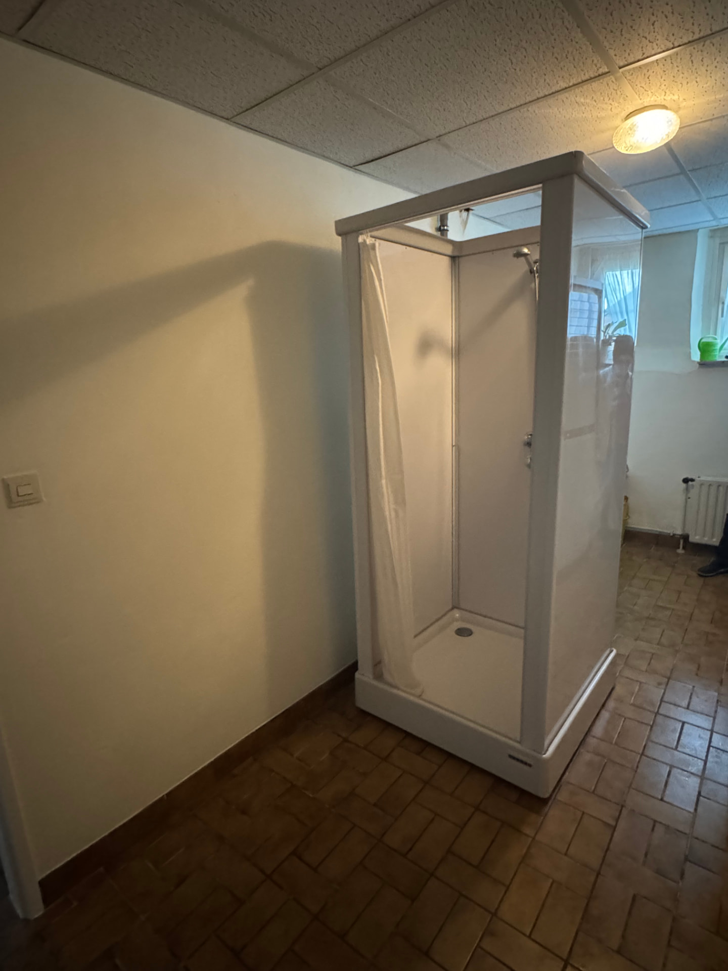 Mobiele douchecabine in een wasruimte voor tijdelijk douchecomfort tijdens herstel na een heupoperatie in Mechelen