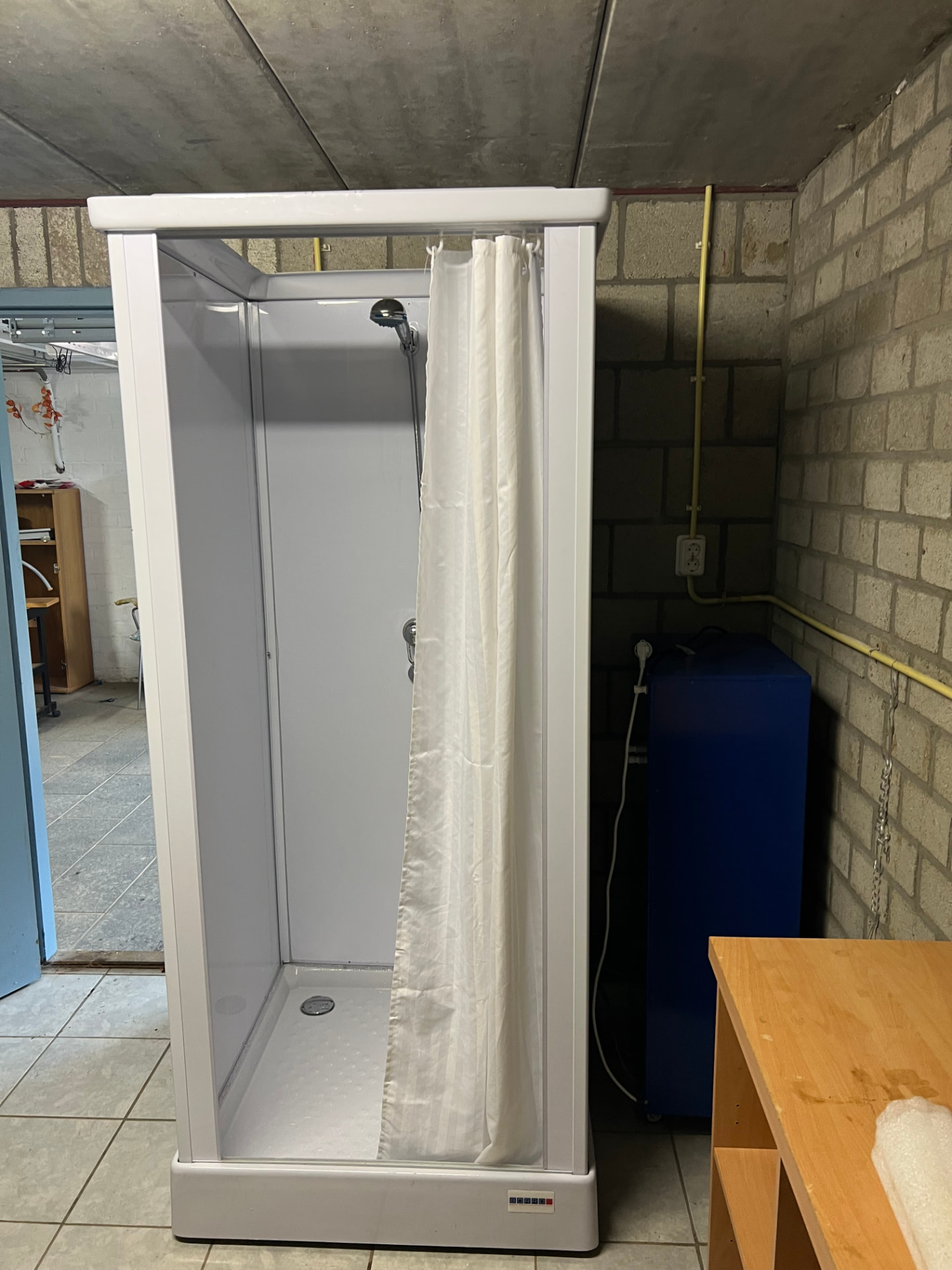 Mobiele douchecabine met mobiele boiler voor seizoenswerkers bij een fruitbedrijf in Klimmen